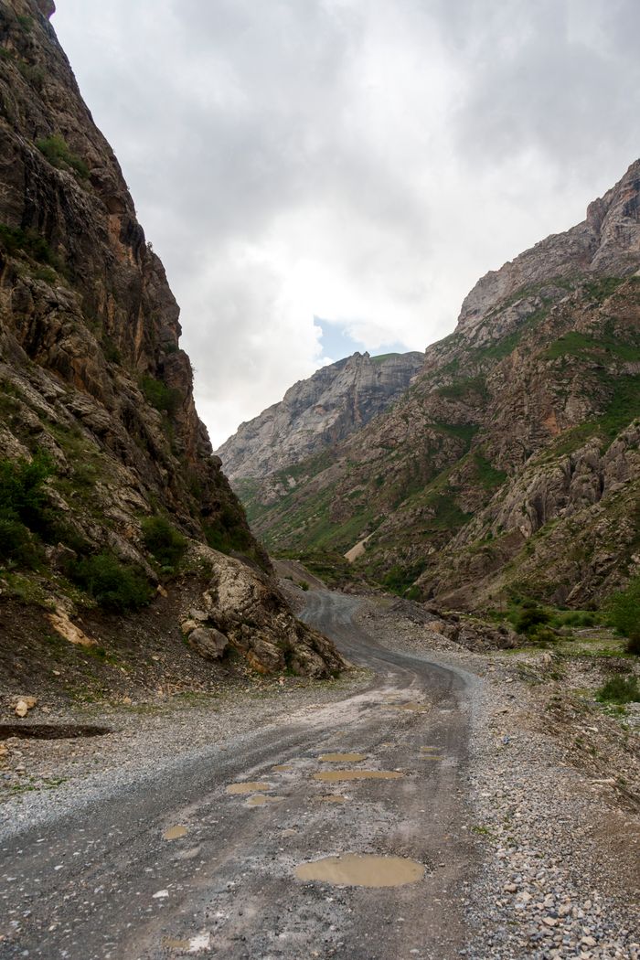 Remote gravel road through a mountainous canyon in the Fann Mountains, Tajikistan.